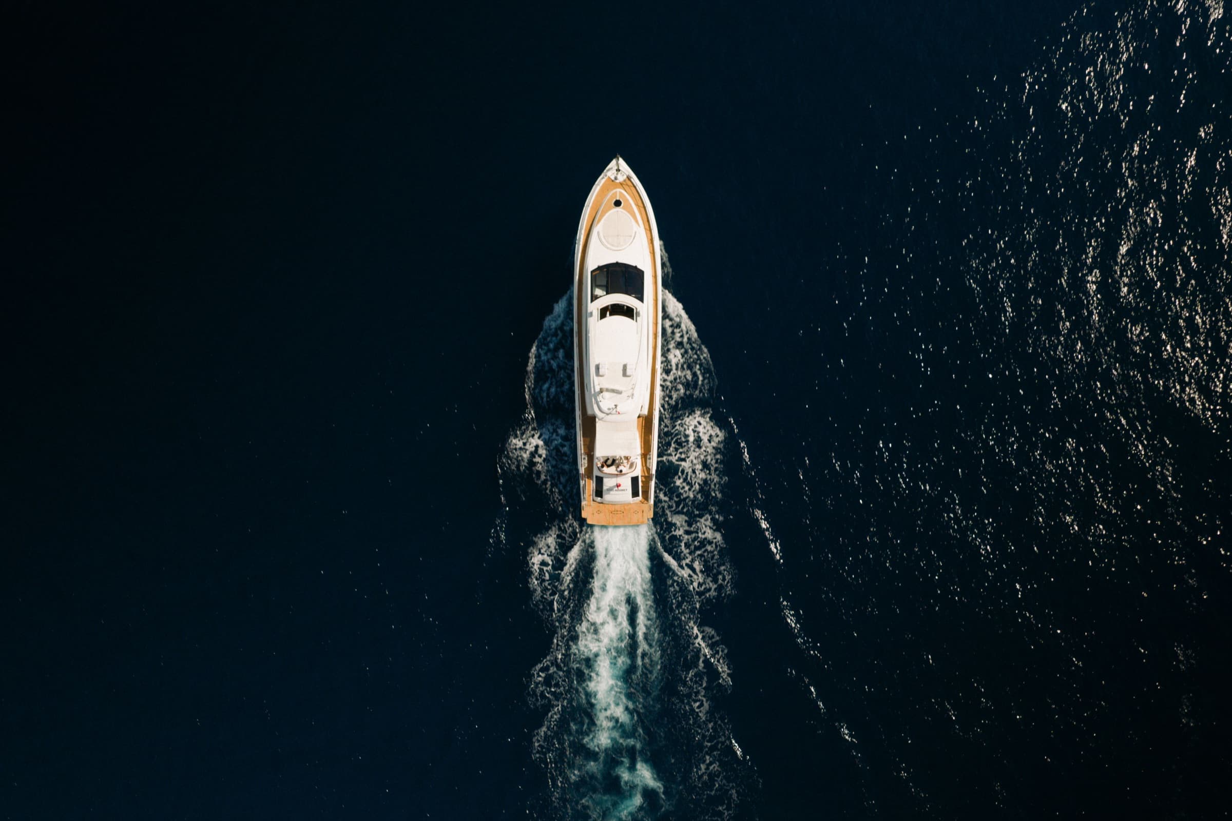 Top-down aerial of Sans Regret on deep navy water