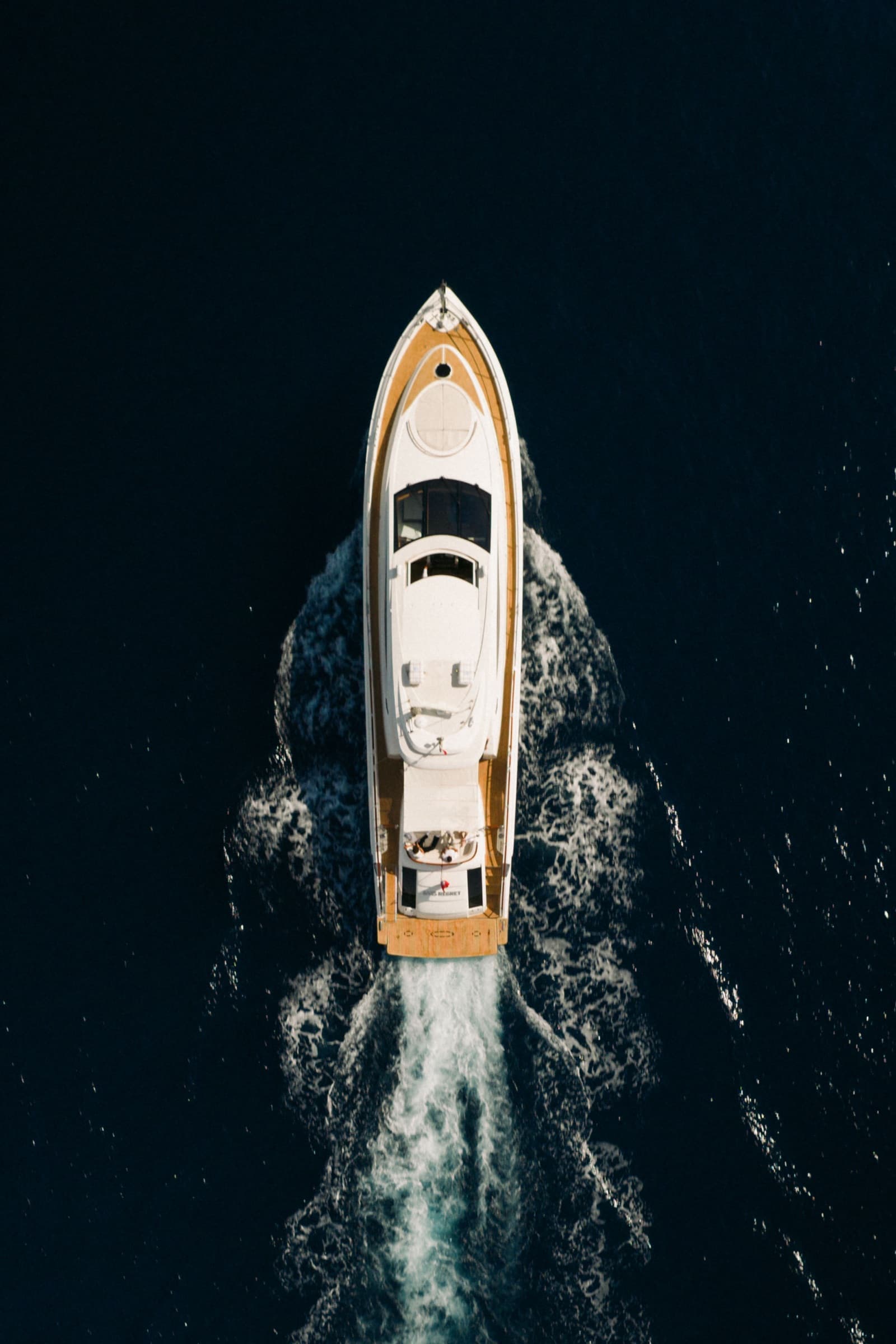 Top-down aerial of Sans Regret cutting through deep blue water